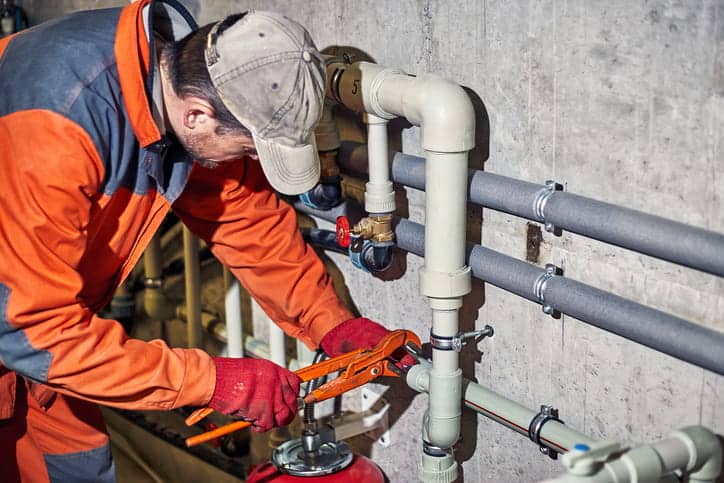 A plumber working on pipes