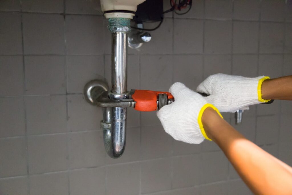 A Las Vegas plumber fixing a pipe to stop a water leak.